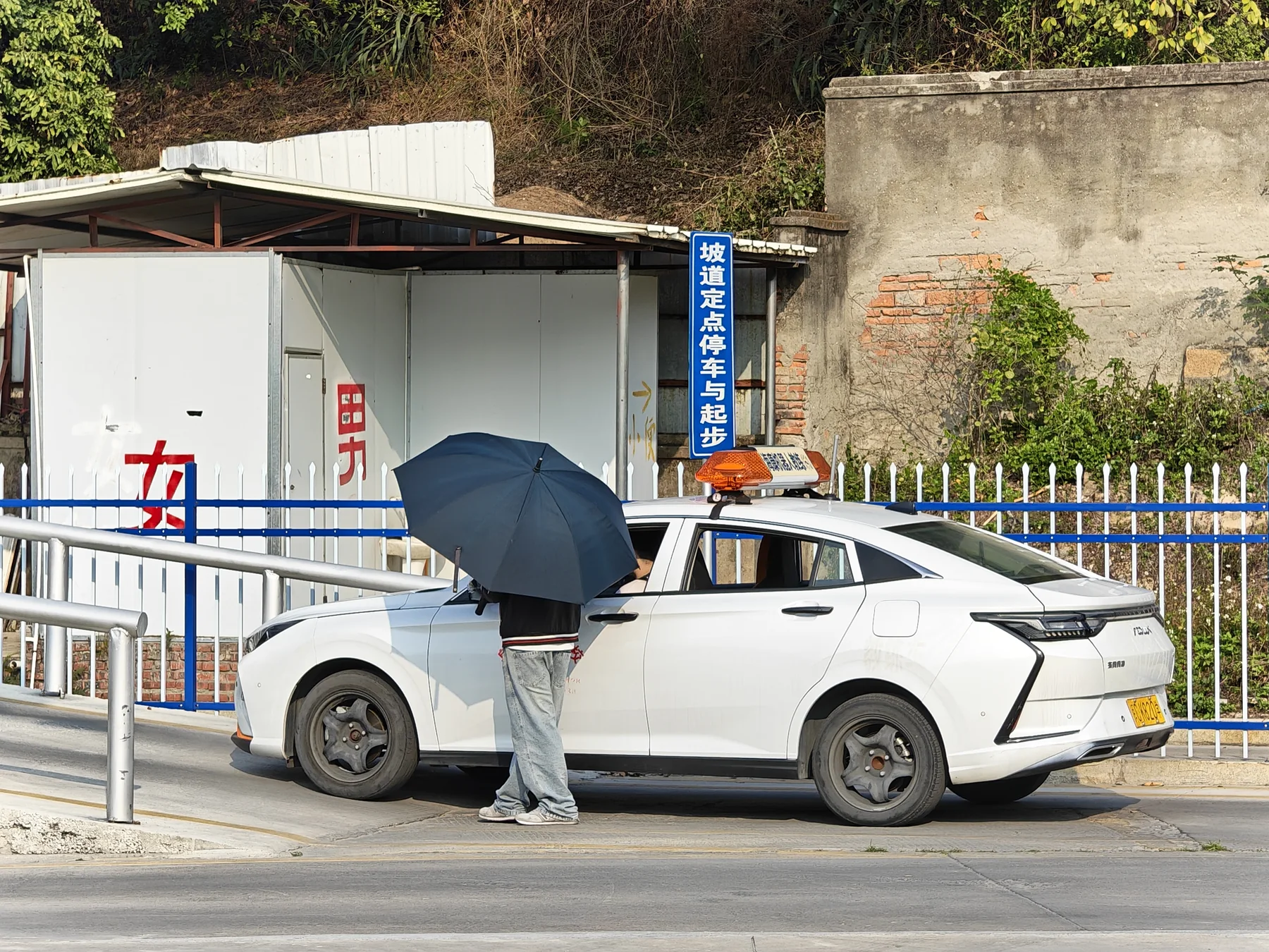学员在坡道定点停车与起步项目旁练车